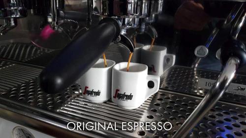 a coffee being poured into mugs in a espresso machine at Hotel Karlštejn & SPA in Karlštejn