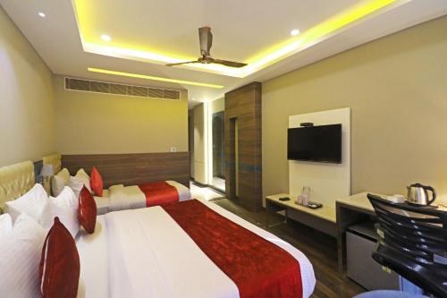 a hotel room with two beds and a flat screen tv at The IVY Grand Hotel - 5 Minutes from Connaught Place and New Delhi Railway Station With Free Secured Parking in New Delhi