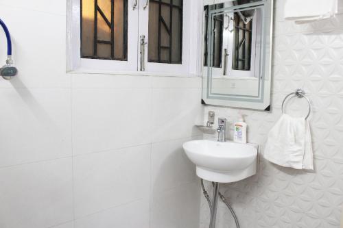 a white bathroom with a sink and a mirror at Furnished 1 Bedroom Independent Apartment 1 in Greater Kailash 1 Delhi in New Delhi