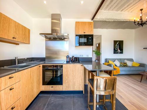 a kitchen with wooden cabinets and a table and a couch at Hotel Relais Du Postillon in Antibes