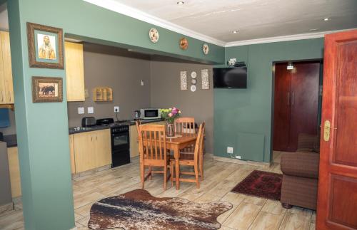 a kitchen and living room with a table and chairs at Big 5 Guest House Witbank in eMalahleni