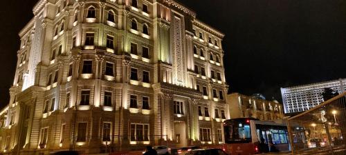 a lit up building on a street at night at Azneft Royal Suite Apartment Sea View in Baku