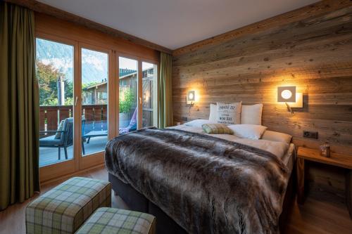 a bedroom with a large bed and a balcony at SALZANO Apartments in Interlaken