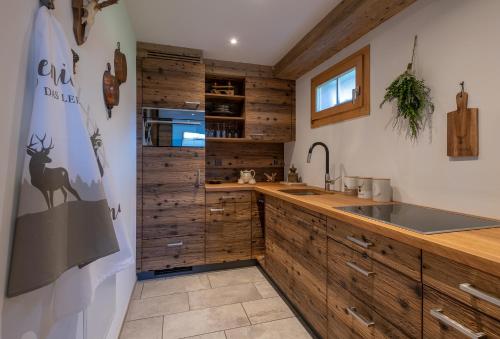 a kitchen with wooden cabinets and a sink at SALZANO Apartments in Interlaken