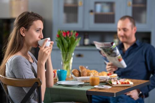 a man and a woman sitting at a table eating food at Ferrata Vendégház in Csesznek