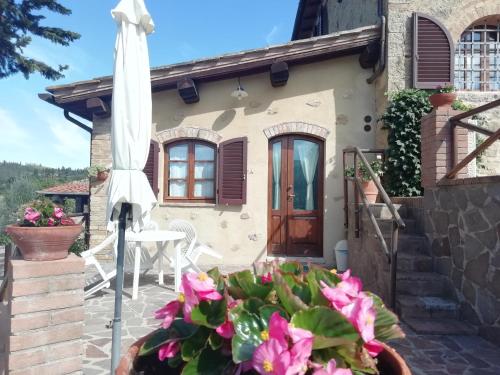 a house with a patio and an umbrella at Poggio Massiccioli in Poggibonsi