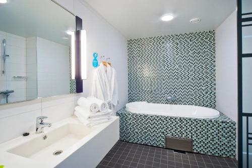 a bathroom with a tub and a sink at Solo Sokos Hotel Lahden Seurahuone in Lahti