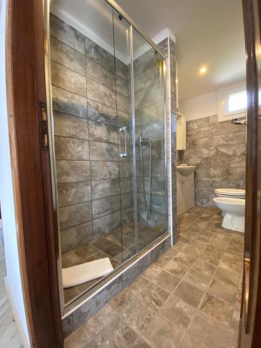 ein Bad mit einer Dusche und einem WC in der Unterkunft Appartamento Cannella in Bellagio