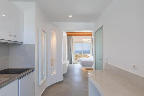 プラティス・ヤロスにあるSea & Stone Residence Mykonosの白いキャビネット付きのキッチン、海の景色を望む