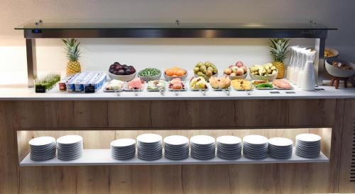 a buffet of food on a shelf with plates at Turia Valencia in Valencia