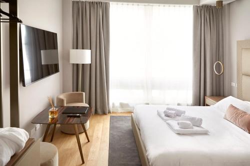 a hotel room with a large bed and a table at PRESTIGE BOUTIQUE APARTHOTEL -Piazza Duomo in Milan