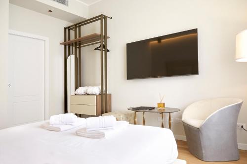 a white room with a television and a chair at PRESTIGE BOUTIQUE APARTHOTEL -Piazza Duomo in Milan