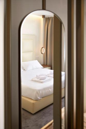 a bedroom with a white bed and a mirror at PRESTIGE BOUTIQUE APARTHOTEL -Piazza Duomo in Milan