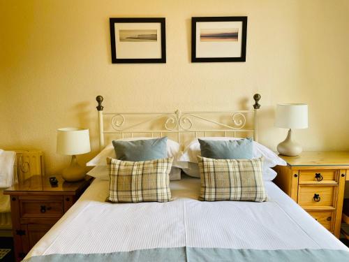 a bedroom with a bed with pillows and two lamps at West Plean House in Stirling