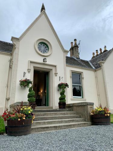a church with stairs and flowers in front of it at West Plean House in Stirling