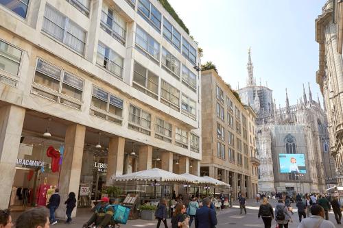 a group of people walking down a city street at PRESTIGE BOUTIQUE APARTHOTEL -Piazza Duomo in Milan