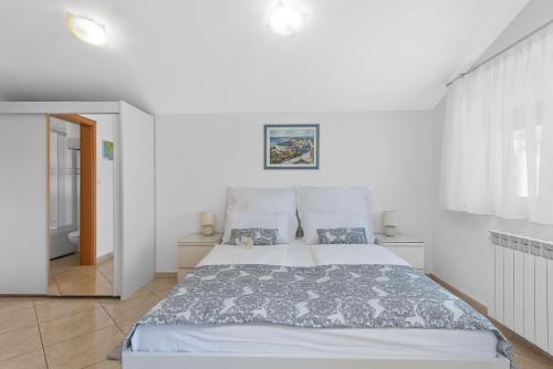Habitación blanca con cama y espejo en Summer house Pula, en Pula