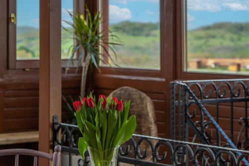 a vase of flowers on a table with a chair at Ferrata Vendégház in Csesznek
