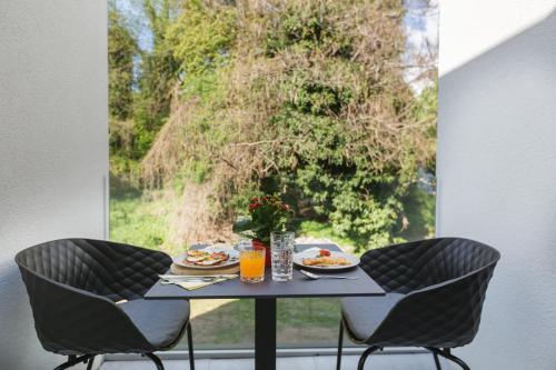 a table with plates of food and drinks in front of a window at Vila Rina in Bled