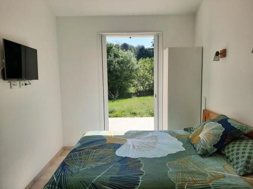 une chambre avec un lit et une grande fenêtre dans l'établissement Studios indépendants dans grand Domaine en pleine nature, à Simiane-Collongue