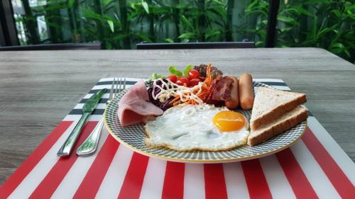 - un plateau de petit-déjeuner composé d'œufs et de pain grillé dans l'établissement Mont Place Donmuang, à Bangkok
