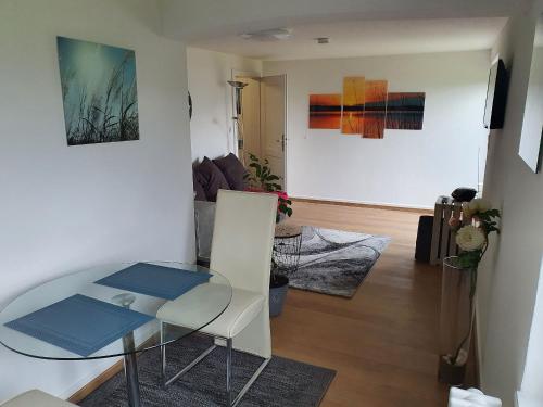a living room with a table and a room with paintings at Ferienwohnung Seegarten in Öhningen