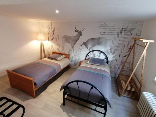 - 2 lits dans une chambre avec un mur en briques dans l'établissement Gîte du centre, à Romorantin-Lanthenay