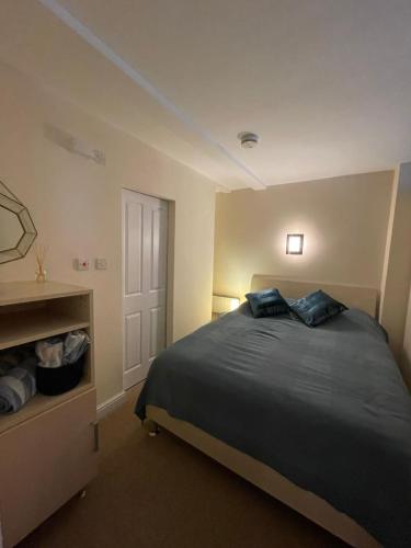 a bedroom with a bed with blue pillows on it at Flat 1 Chestergate in Macclesfield