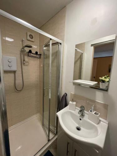 uma casa de banho com um lavatório e um chuveiro em Flat 1 Chestergate em Macclesfield