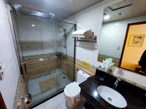 a bathroom with a glass shower and a sink at 456 Hotel in Baguio