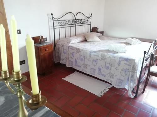 a bedroom with a bed and a table and two candles at Poggio Massiccioli in Poggibonsi
