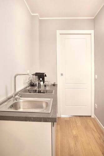 a kitchen with a sink and a white door at PRESTIGE BOUTIQUE APARTHOTEL -Piazza Duomo in Milan