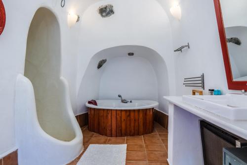 a bathroom with two sinks and a bath tub at AURORA VILLA by K&K in Oia