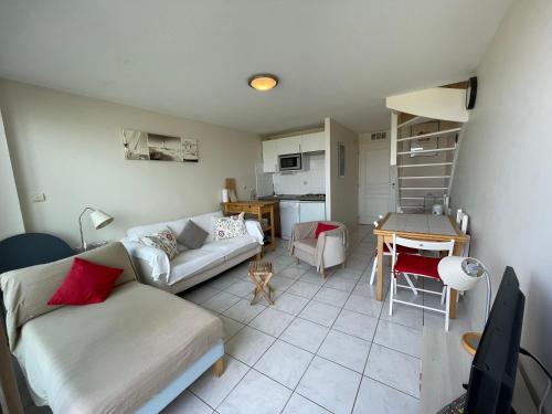 un salon avec un canapé et une table dans l'établissement L'Oustalet, à Mimizan