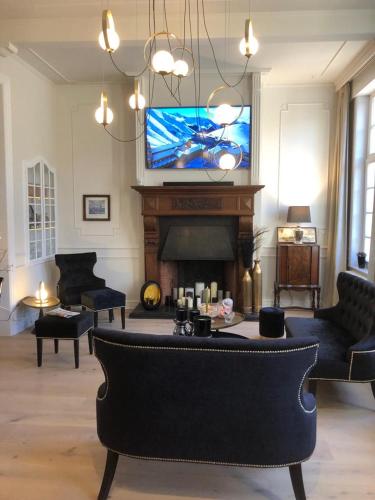 a living room with a fireplace and a tv at St-Georges IV in Ypres