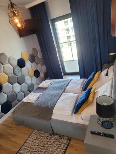 a bedroom with a large bed and a window at Apartament SZAFIROWY Gardenia Dziwnów z widokiem na morze in Dziwnów