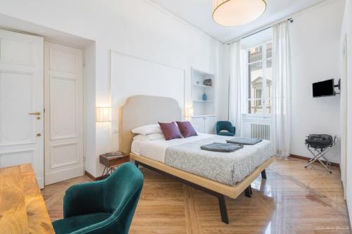 una camera bianca con un letto e due sedie di Vin Novo Rooms & Apartments a Firenze