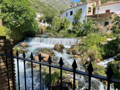 a waterfall in a town with a fence at Casa Lucía y Clara benaojan in Benaoján
