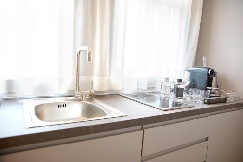 a kitchen counter with a sink and a window at PRESTIGE BOUTIQUE APARTHOTEL -Piazza Duomo in Milan