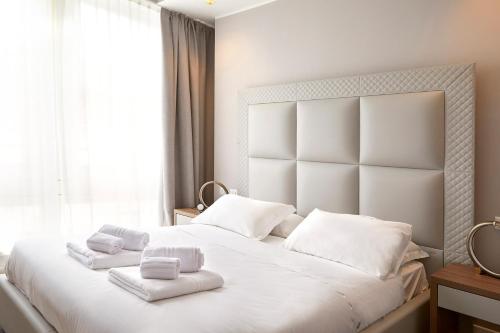 a bedroom with a large white bed with towels on it at PRESTIGE BOUTIQUE APARTHOTEL -Piazza Duomo in Milan