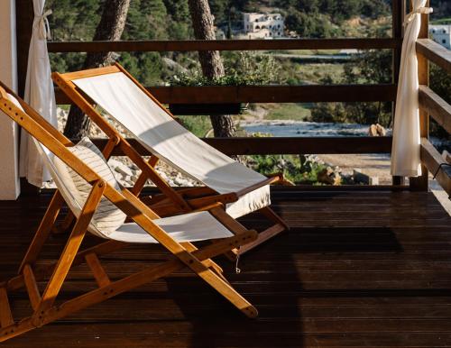 a wooden rocking chair sitting on a porch at Nature House with a wooden porch - Pasika, house Tonka in Pučišća