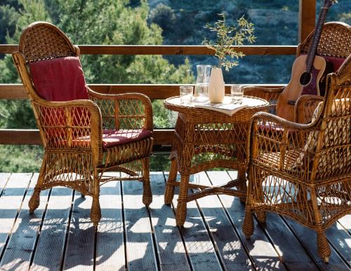 uma mesa e cadeiras num alpendre com uma guitarra em Nature House with a wooden porch - Pasika, house Tonka em Pucisca