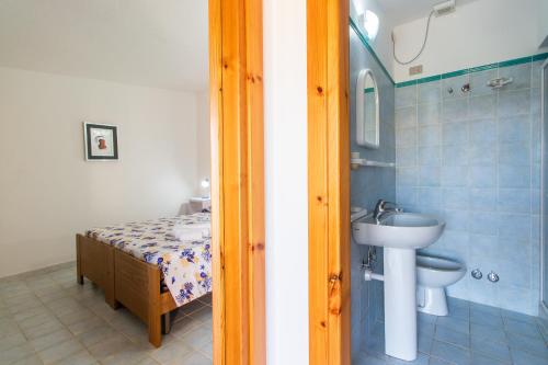 uma casa de banho com um lavatório, um WC e um chuveiro em Michelina em Capo Testa