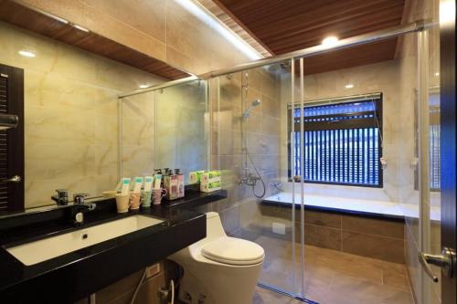 a bathroom with a toilet and a sink and a shower at 花蓮漫漫時光電梯包棟民宿 in Hualien City