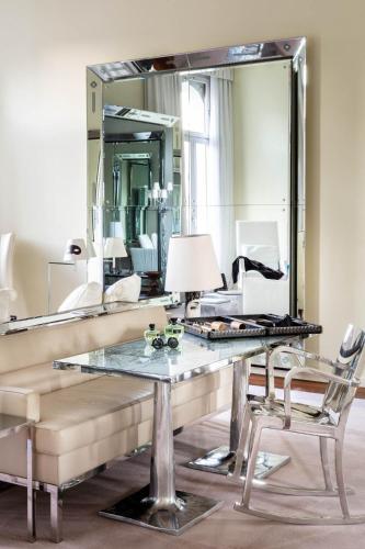 a living room with a table and a mirror at Hotel Palazzina Grassi in Venice