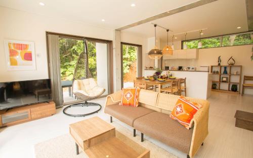 a living room with a couch and a tv at K's Casa 恩納村 in Meta