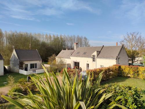 een groot wit huis in een tuin met planten bij Les Logis d Ussé in Rigny-Ussé