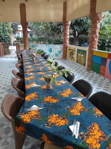 a long table with a blue table cloth on it at Franco Inn Guesthouse in Tanji