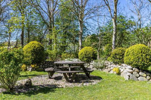 a picnic table in the middle of a garden at Denkerhof Fewo Blume des Lebens in Reußenköge
