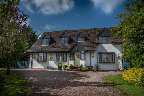 a white house with a black roof at Innes House Bed & Breakfast in Acharacle